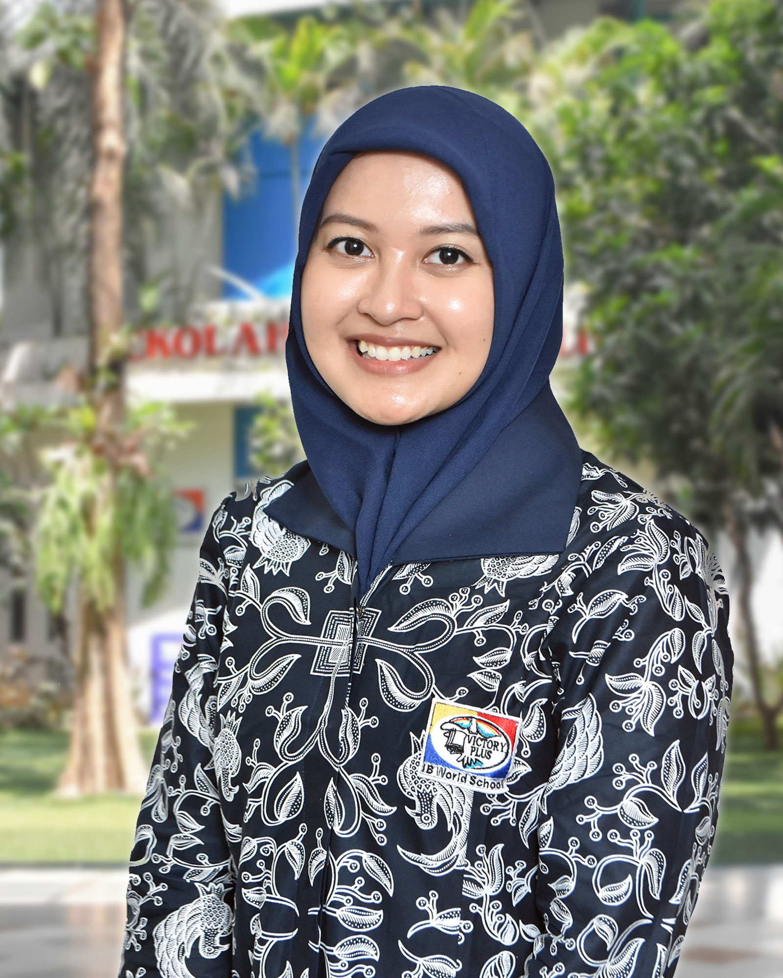 A female teacher of Sekolah Victory Plus - The Renowned International Baccalaureate School in Bekasi, Indonesia is posing in front of the school.