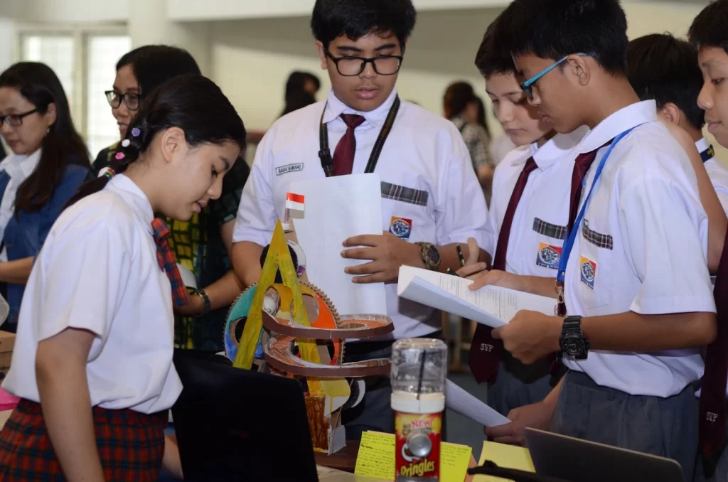 Three students of Sekolah Victory Plus - The leading International Baccalaureate School in Bekasi are presenting at a science fair