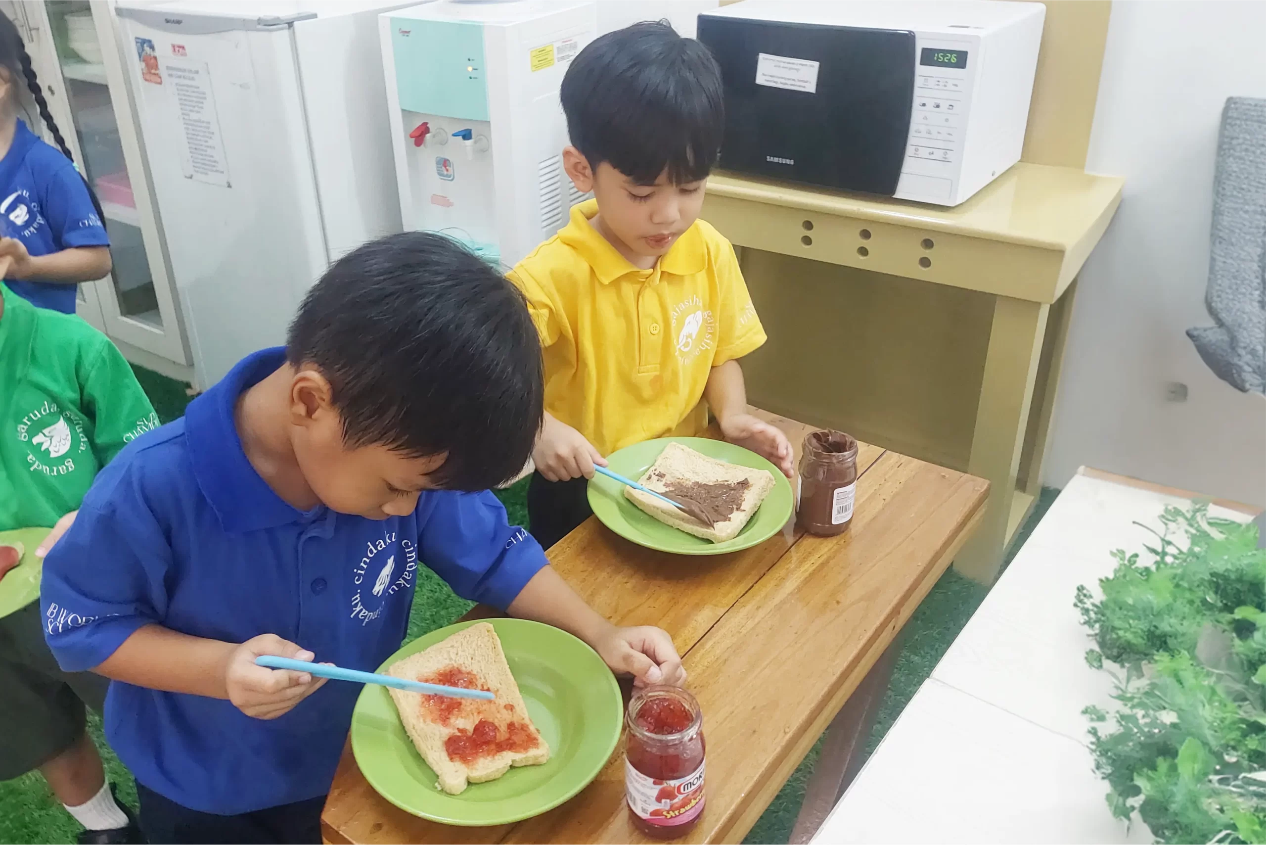 Two students of Early Childhood Education Programme at Sekolah Victory Plus - The leading International Baccalaureate School in Indonesia are preparing their breakfast.