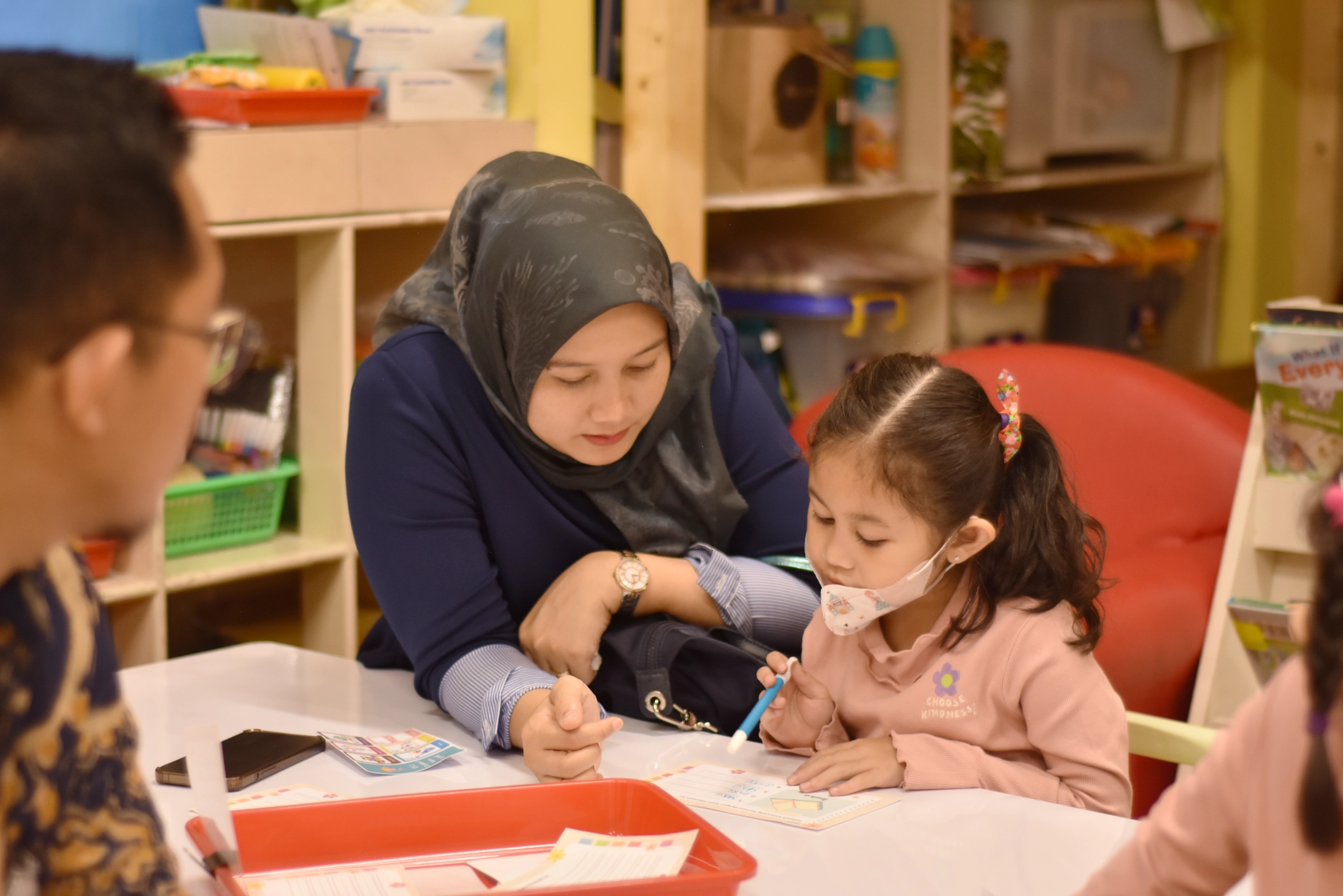 An early childhood education student and her parents are having a Student led conference at Sekolah Victory Plus - the leading International Baccalaureate School in Indonesia