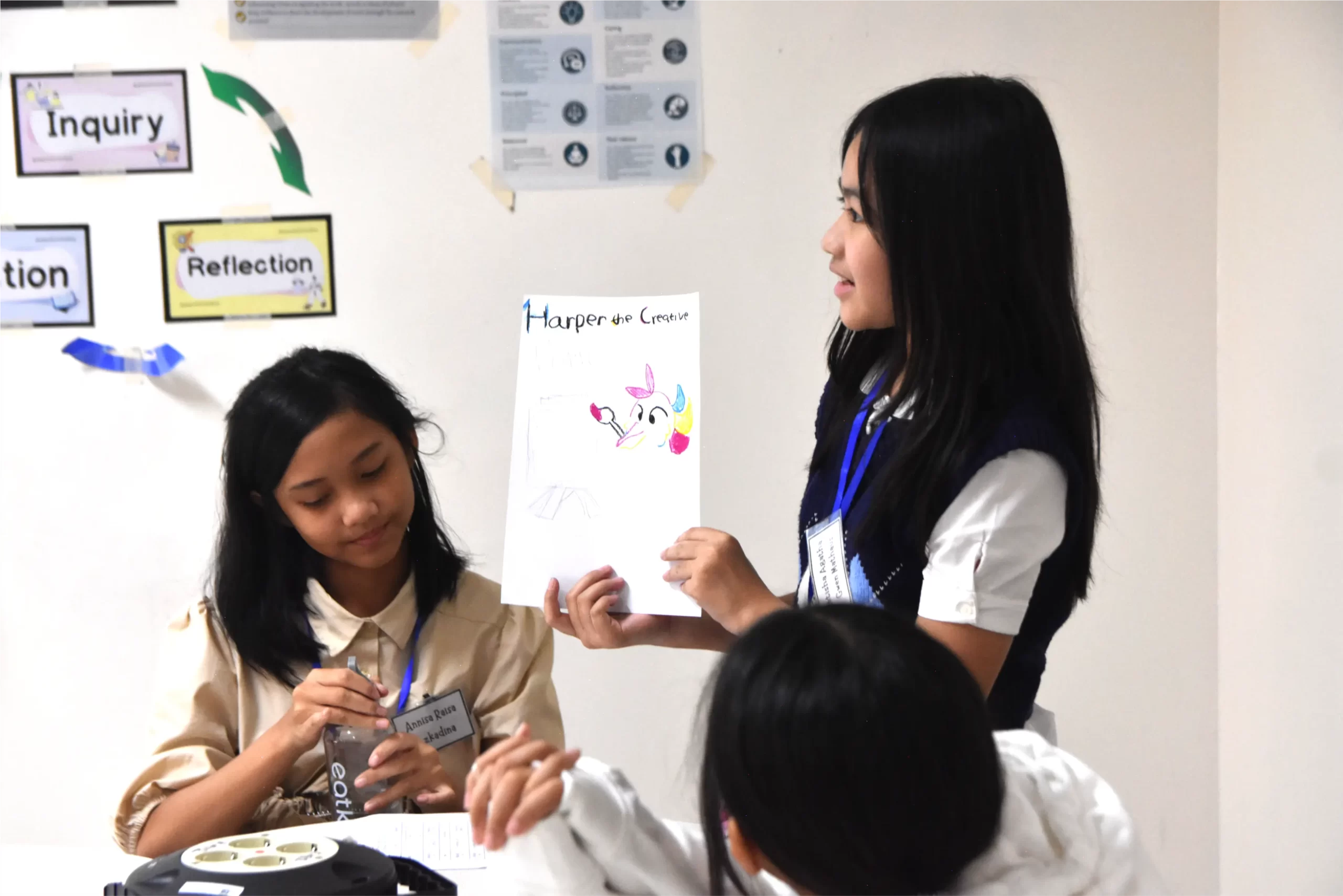 Two IB Middle Years Programme students are presenting in front of the classroom